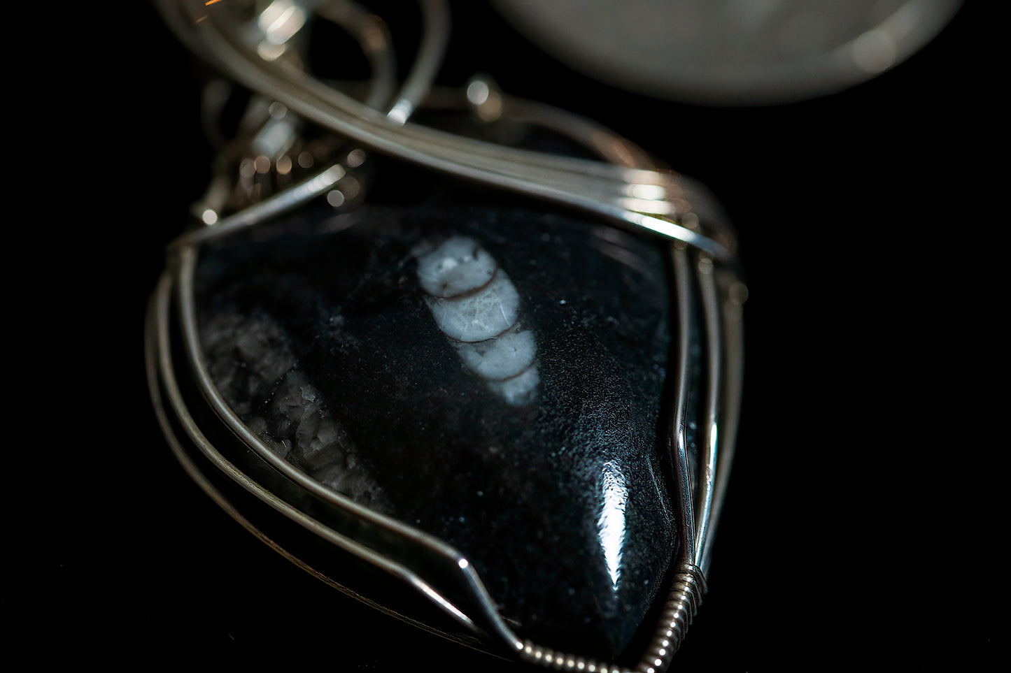 Fossil in basalt wrapped in .925 sterling silver wire