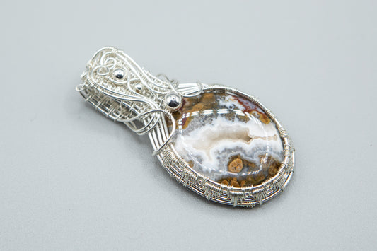 Silver woven basket holding a druzy moss agate