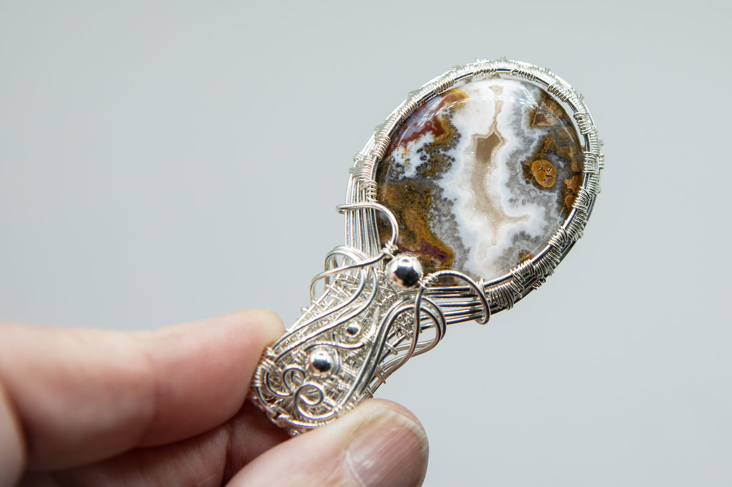 Silver woven basket holding a druzy moss agate