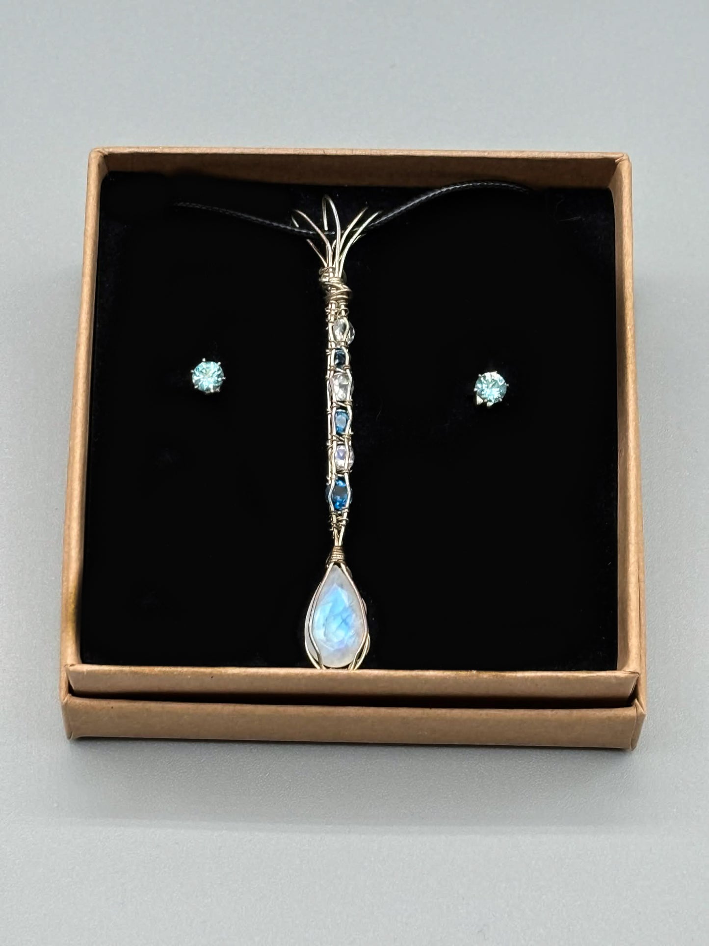 Blazing blue Moonstone Facet accented with Swiss Topaz wrapped in Sterling Silver