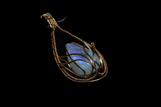 Translucent, blue flash Moonstone wrapped in Fine Copper Lotus Cage