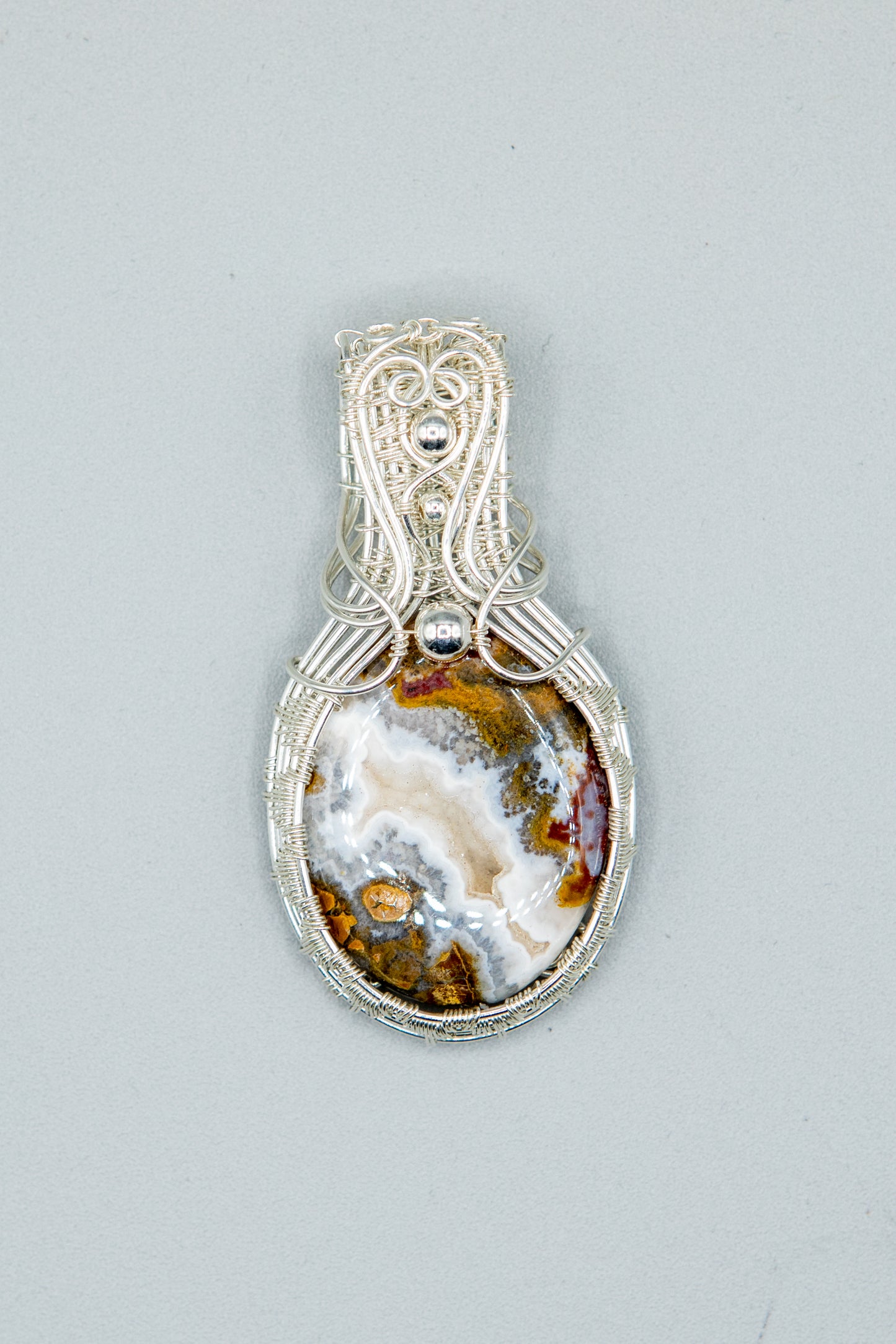 Silver woven basket holding a druzy moss agate