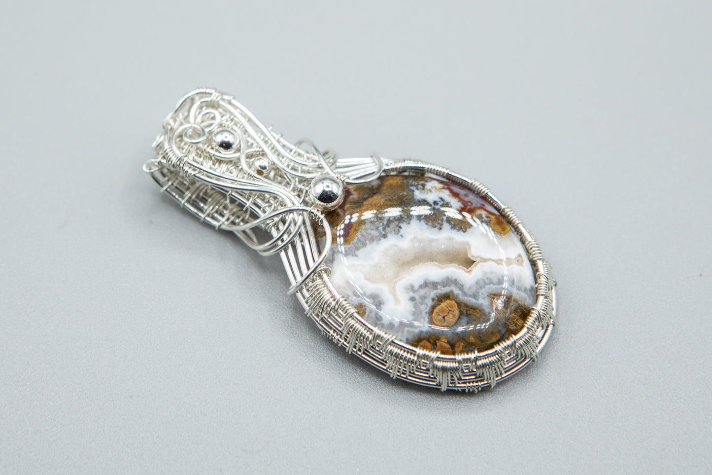 Silver woven basket holding a druzy moss agate