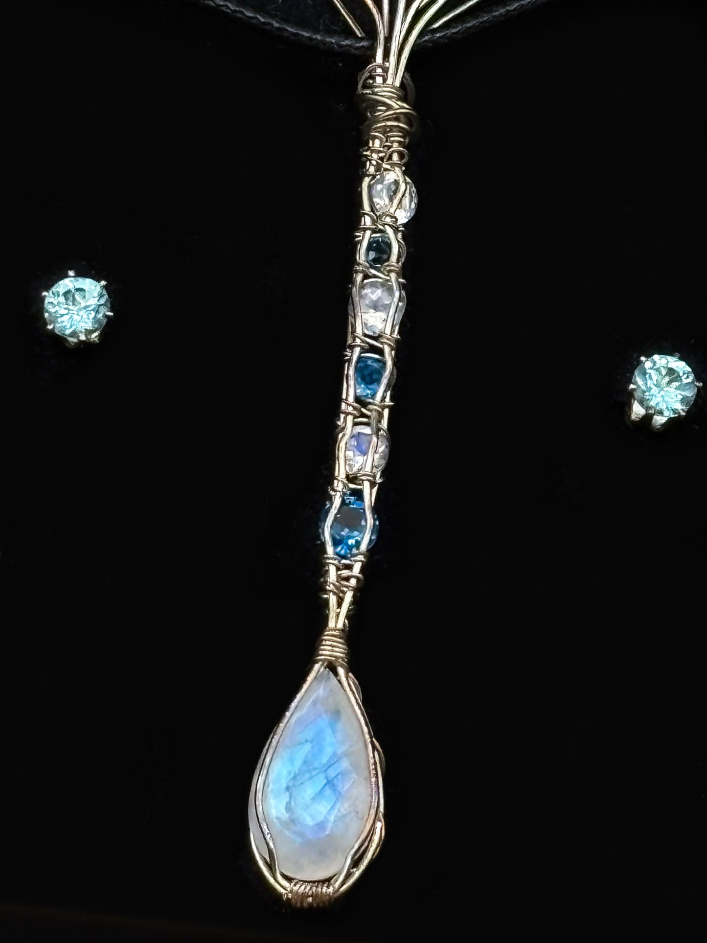 Blazing blue Moonstone Facet accented with Swiss Topaz wrapped in Sterling Silver